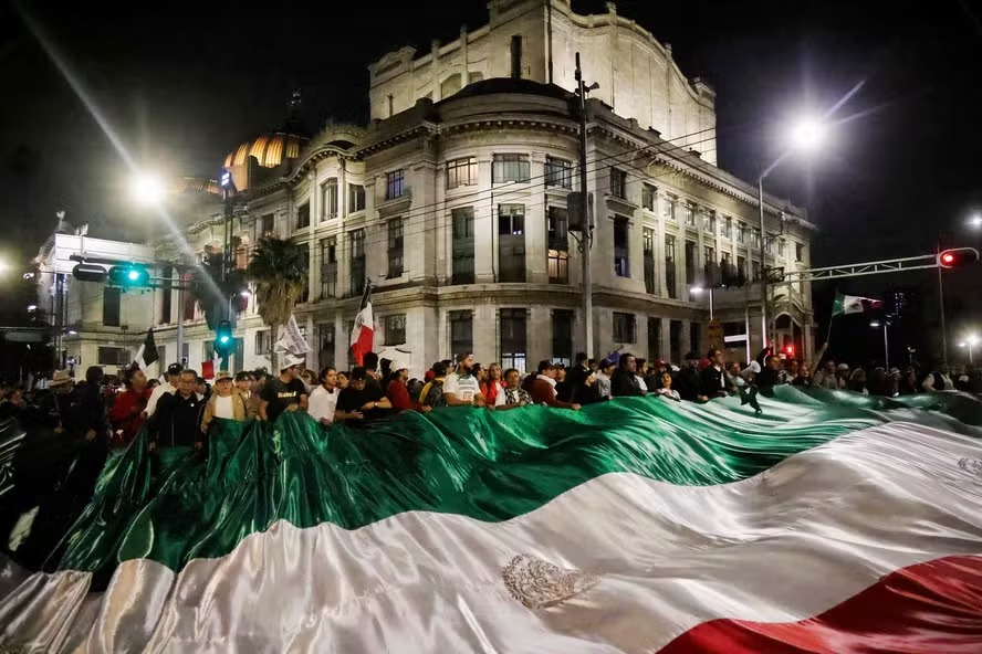 Trabalhadores do Judiciário e estudantes seguram bandeira gigante enquanto bloqueiam as ruas próximas à antiga sede do Senado mexicano 