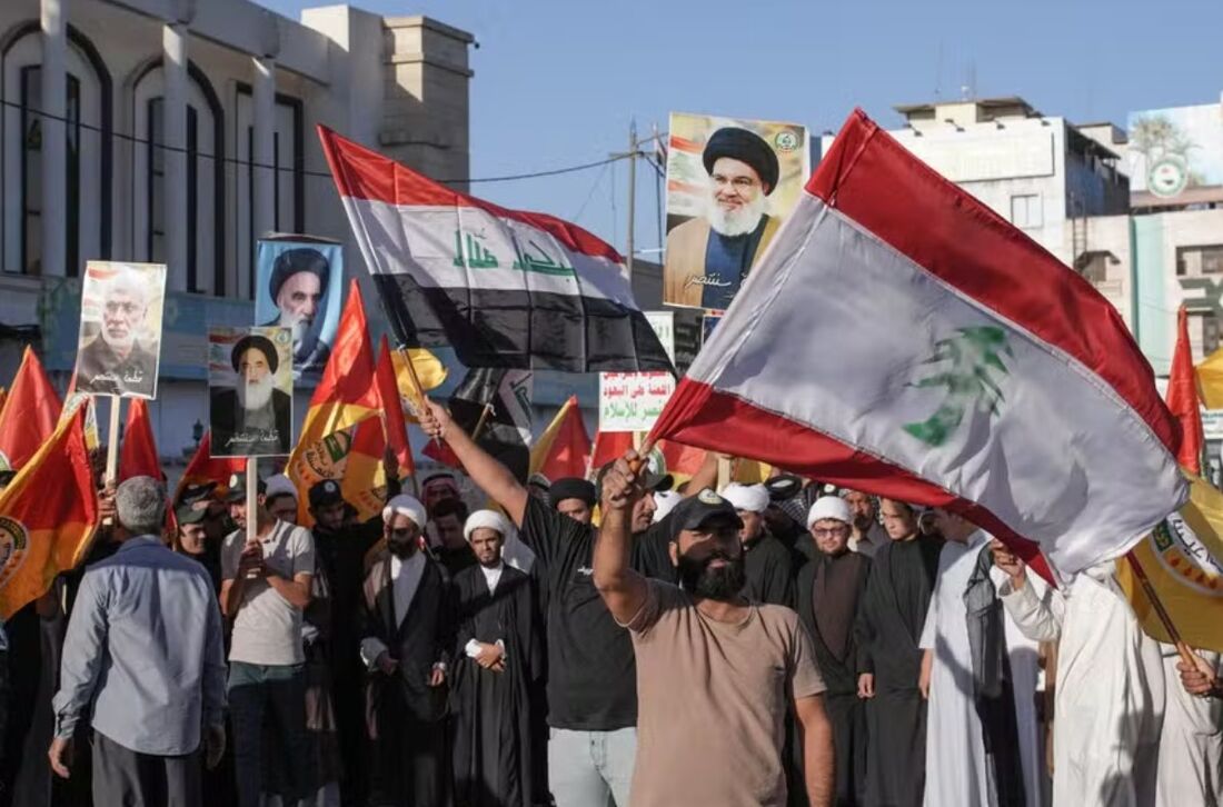 Apoiadores das Brigadas Hezbollah do Iraque agitam bandeiras libanesas e iraquianas enquanto demonstram solidariedade ao movimento Hezbollah do Líbano na cidade sagrada central de Najaf 