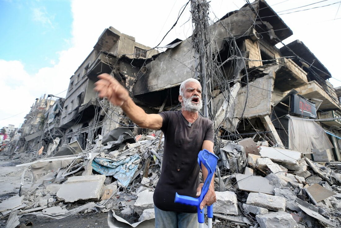 Um homem segura suas muletas enquanto reage em frente à destruição um dia após os ataques aéreos israelenses que atingiram a cidade de Nabatiyeh, no sul do Líbano