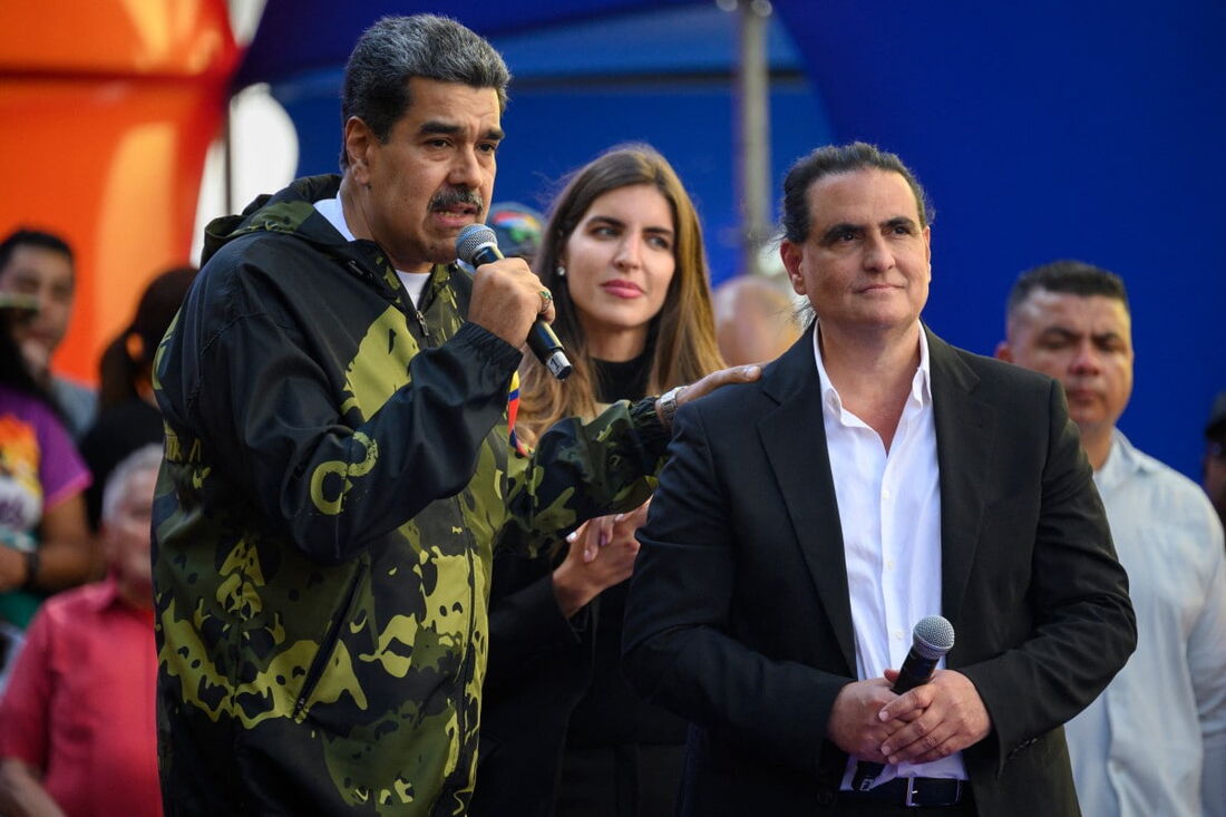 O presidente da Venezuela, Nicolás Maduro (E), fala com apoiadores ao lado do empresário colombiano Alex Saab durante um comício em apoio ao seu governo em Caracas, em 23 de janeiro de 2024.