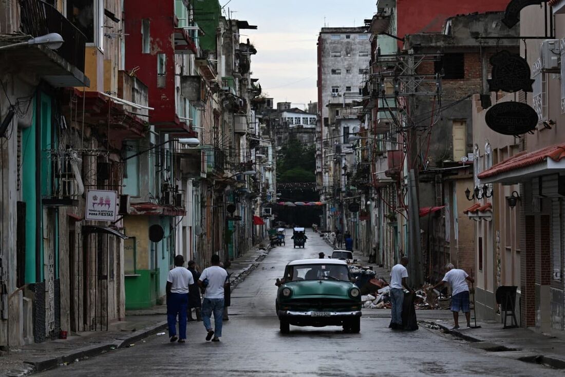 Pessoas caminham por uma rua durante o quarto dia de uma grande queda de energia em Havana em 21 de outubro de 2024.