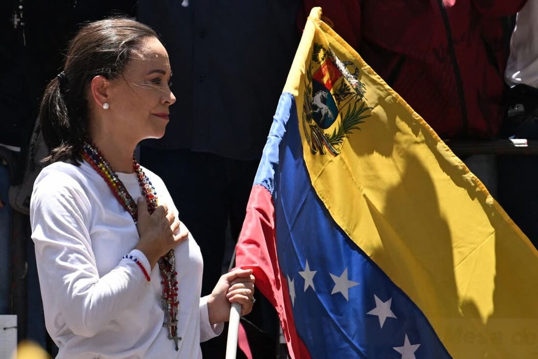 A líder da oposição venezuelana Maria Corina Machado segura uma bandeira nacional venezuelana