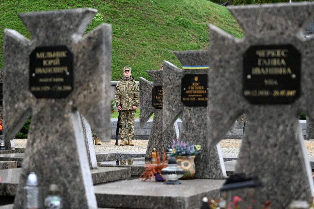 Uma guarda de honra ucraniana fica perto dos túmulos de soldados ucranianos mortos no cemitério de Lychakiv no "Dia Nacional dos Defensores" 