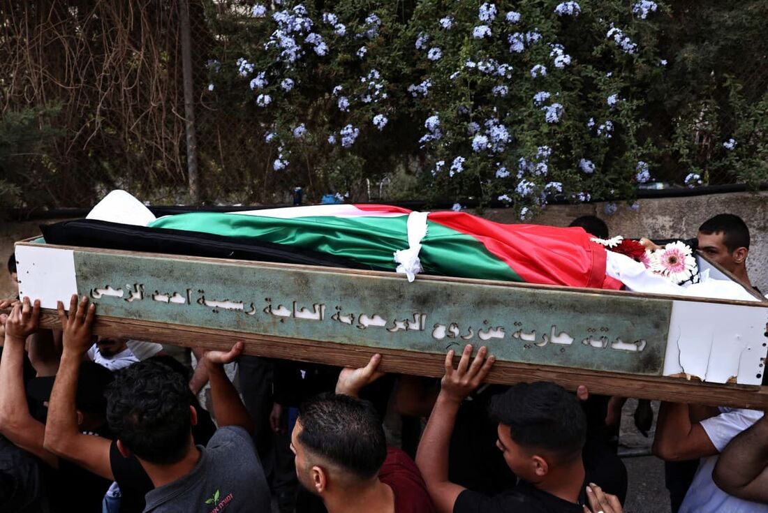 Pessoas em luto carregam o corpo do palestino Hatem Sami Ghaith, de 12 anos, que morreu em consequência de ferimentos sofridos durante um ataque israelense