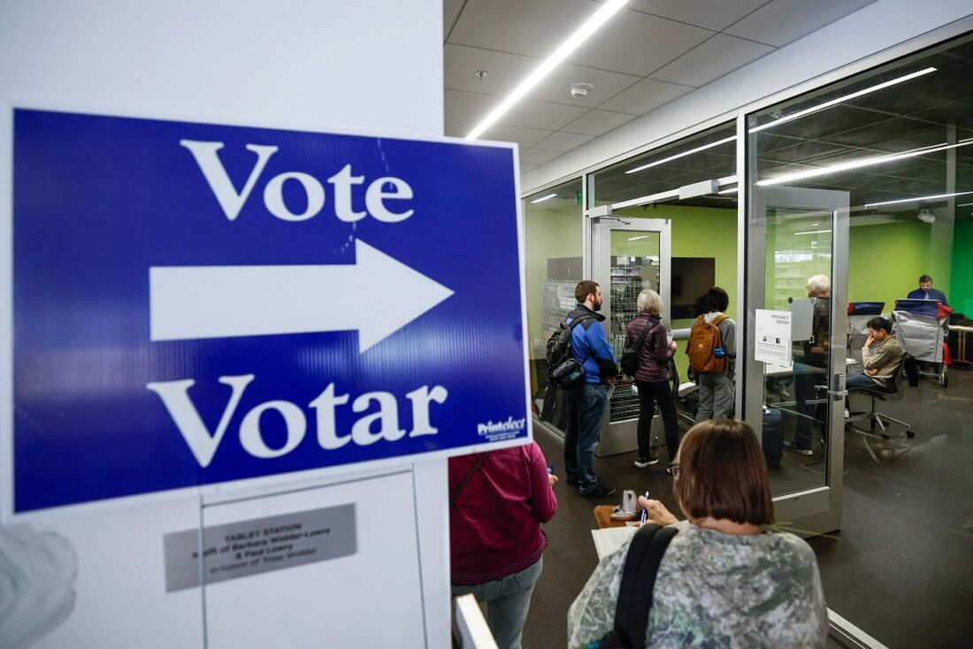 Os primeiros eleitores esperam na fila para votar em um local de votação antecipada na Biblioteca Pública de Madison  Central em Madison, Wisconsin