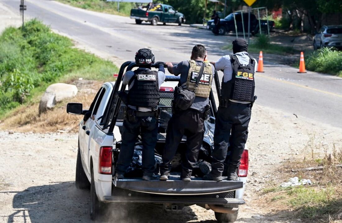 Policiais mexicanos retiram corpos de pessoas que morreram em confronto armado