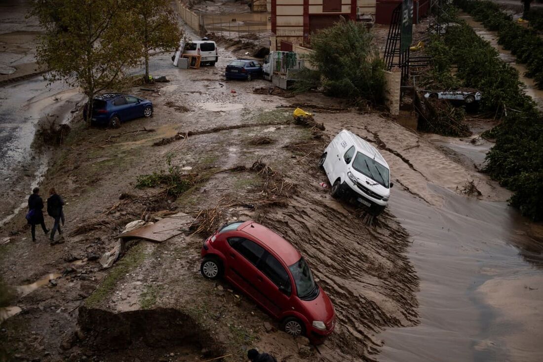 Carros levados por um deslizamento de terra são fotografados em uma rua inundada em Alora, perto de Málaga, em 30 de outubro de 2024, após fortes chuvas atingirem o sul da Espanha.