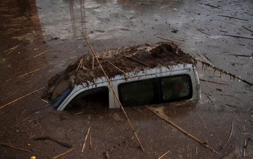 Carro ficou coberto de lama em uma rua alagada em Alora, perto de Málaga, após temporal atingir o sul da Espanha 