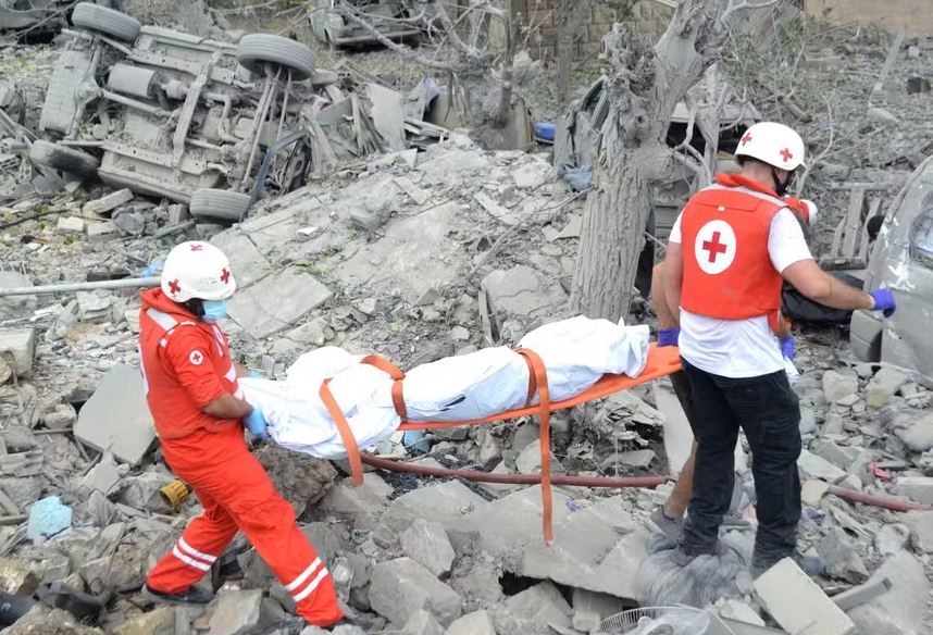 Equipe da Cruz Vermelha retira corpo de local bombardeado por Israel em Aito, no norte do Líbano 