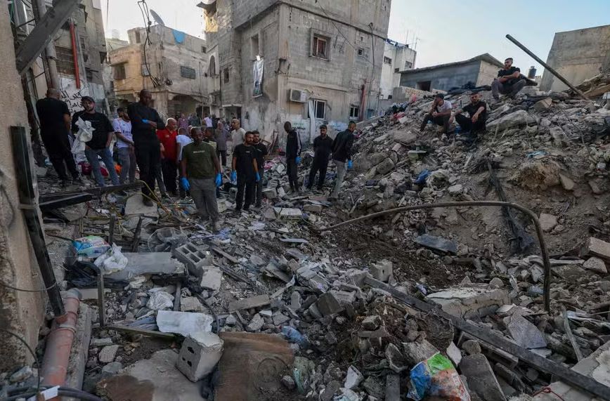 Pessoas observam destroços em local de ataque aéreo de Israel em Tulkarem, na Cisjordânia