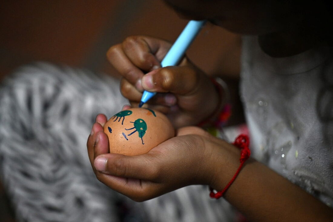 Uma menina pinta uma boneca durante a visita do Fundo Global para Crianças à Fundação Girls of Light no bairro Ciudad Bolivar em Bogotá em 6 de novembro de 2024.