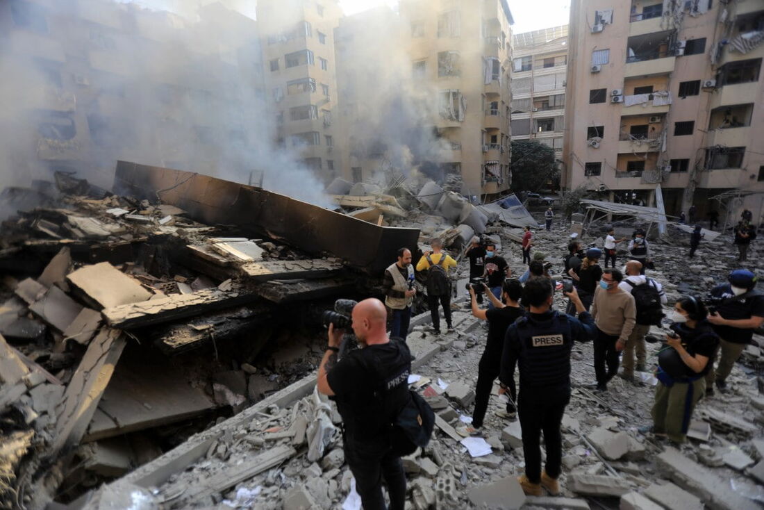 Membros da imprensa avaliando a destruição no local dos ataques aéreos israelenses durante a noite, em 7 de novembro