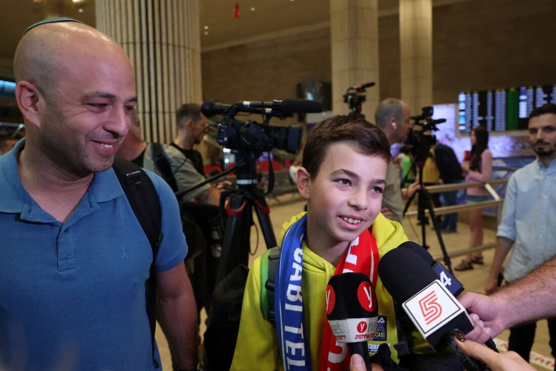 Um jovem fã do clube de futebol israelense Maccabi Tel-Aviv é entrevistado por membros da mídia no Aeroporto Internacional Ben Gurion, nos arredores de Tel Aviv