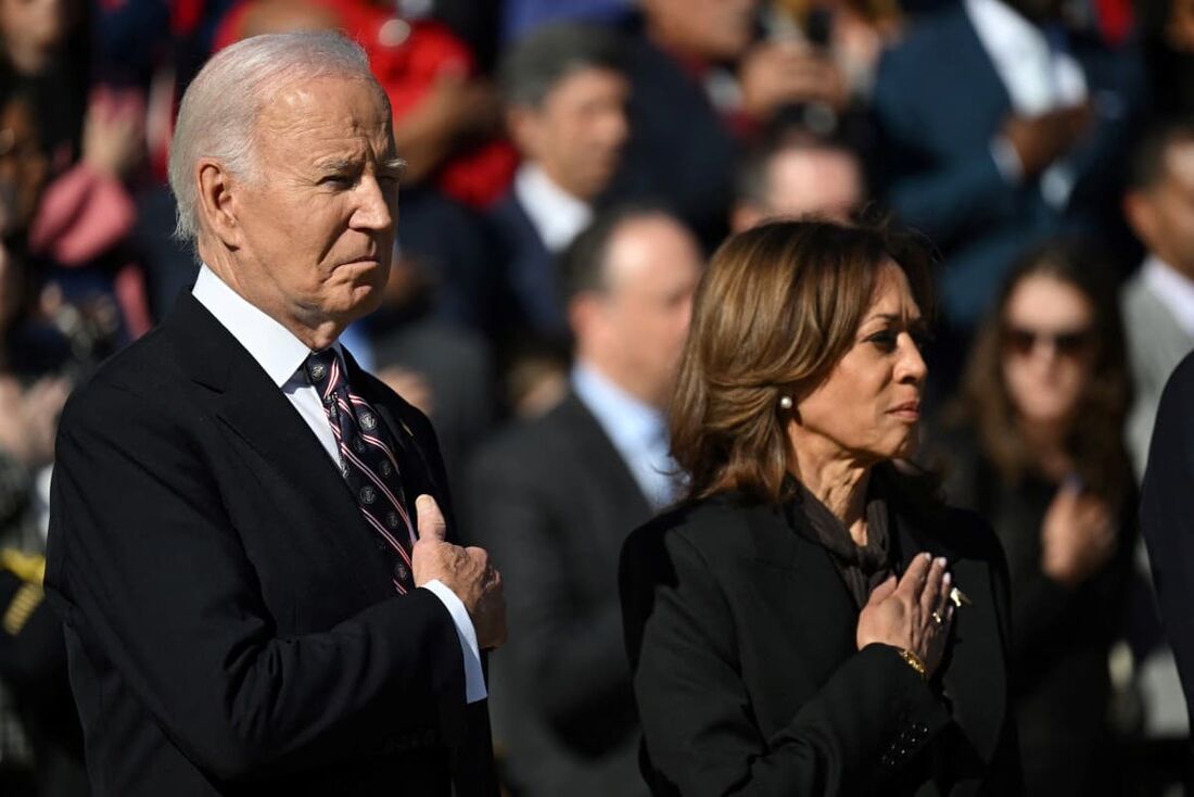 O presidente dos EUA, Joe Biden (E), e a vice-presidente Kamala Harris em posição de sentido durante uma cerimônia