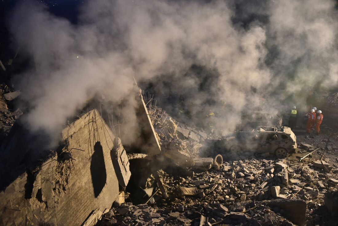 Equipes de resgate trabalham no local de um ataque aéreo israelense que teve como alvo uma casa onde viviam pessoas deslocadas no vilarejo de Baalshmay, nas montanhas libanesas