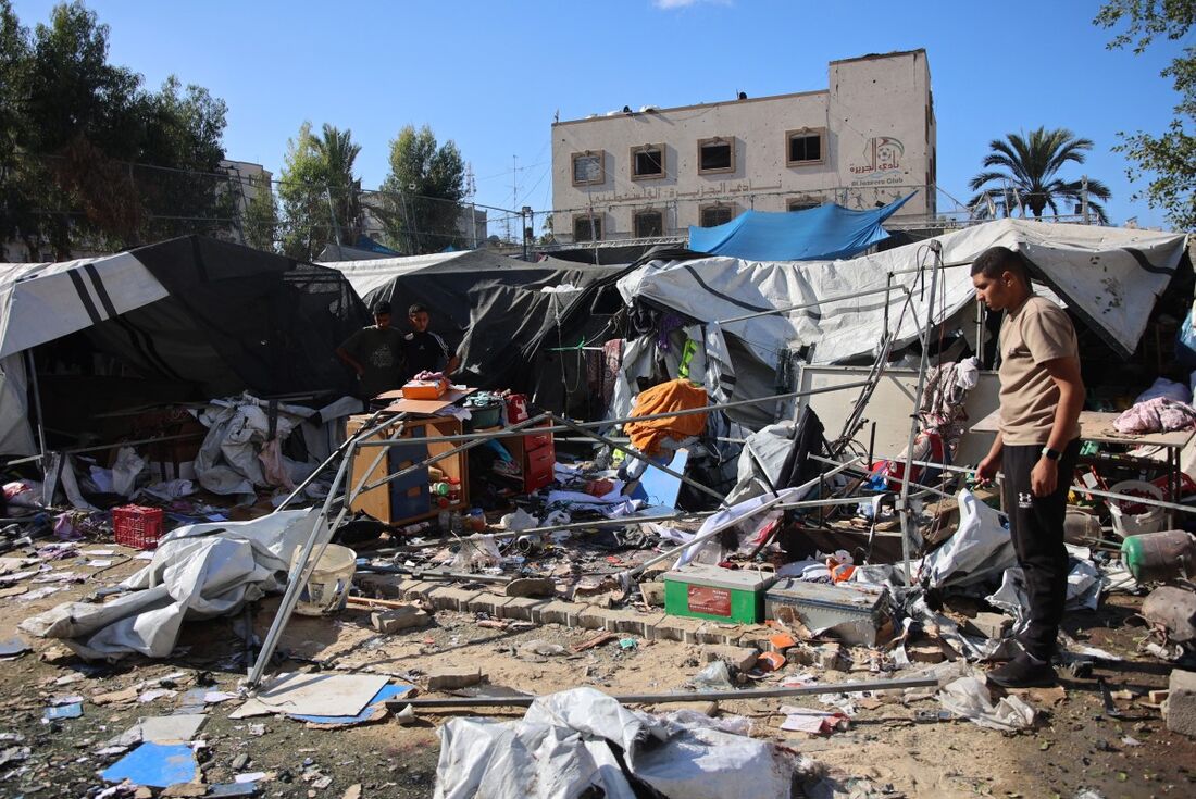 Palestinos inspecionam os danos após o bombardeio israelense que atingiu um campo para deslocados de outras partes do norte de Gaza, dentro do Clube Esportivo Al-Jazira, na cidade de Gaza