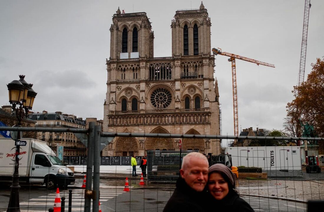 Turistas posam para uma fotografia em frente à Catedral de Notre-Dame de Paris, em Paris, em 18 de novembro de 2024.