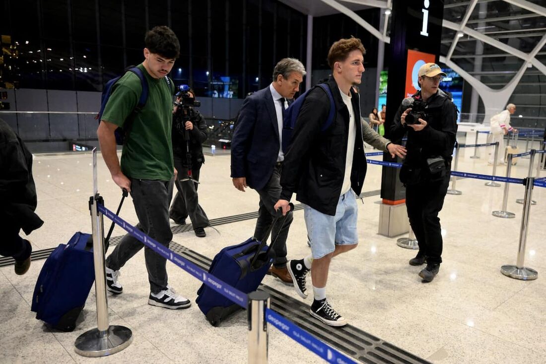 Os jogadores de rúgbi franceses Hugo Auradou (E) e Oscar Jegou (2&ordm; D) e seu advogado Rafael Cuneo Libarona (C) 