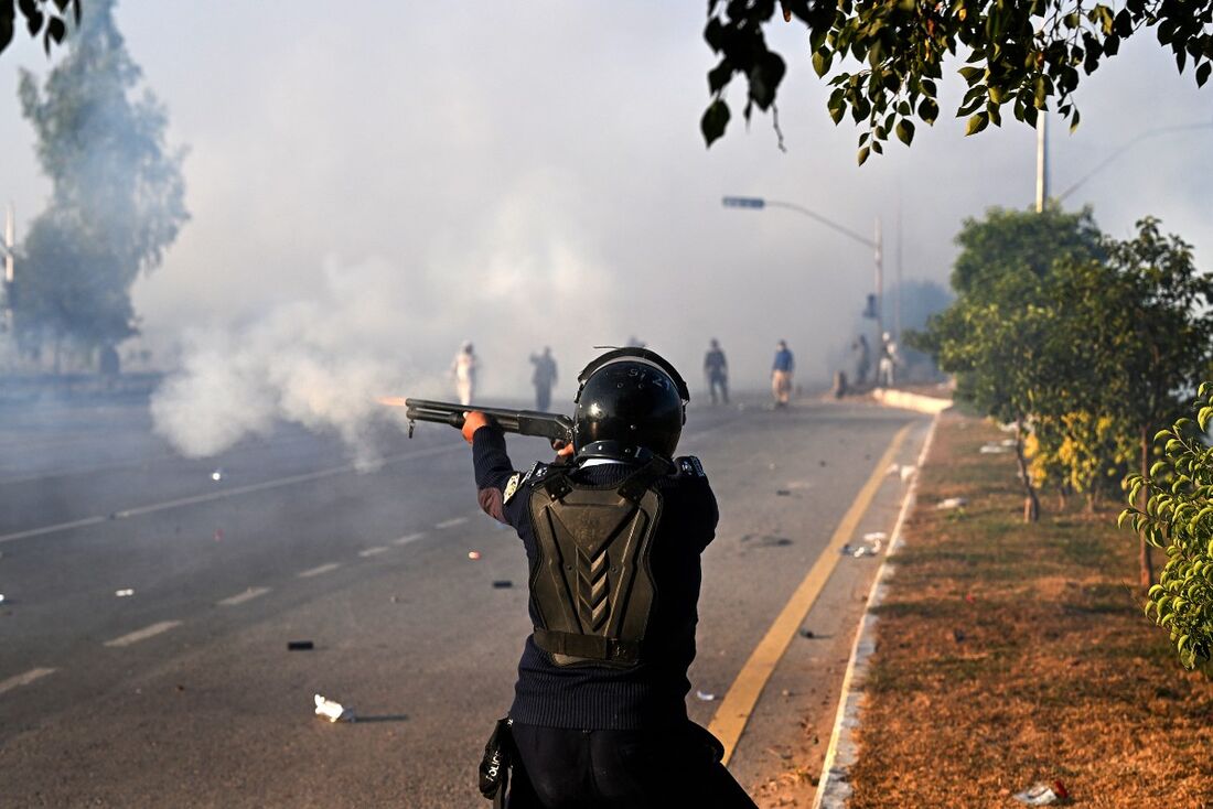 Policial dispara balas de borracha para dispersar apoiadores do partido paquistanês Tehreek-e-Insaf (PTI) durante um protesto