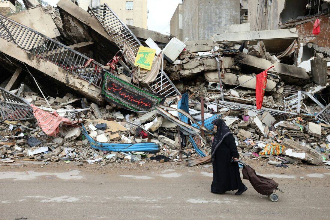 Um residente passa pela destruição causada pelo bombardeio israelense 