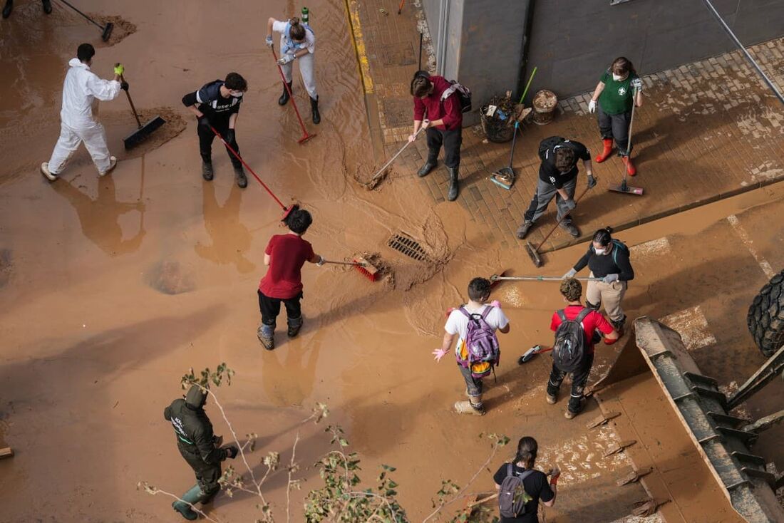 Pessoas trabalham para limpar lama e detritos de uma rua em Aldaia, na região de Valência, leste da Espanha.