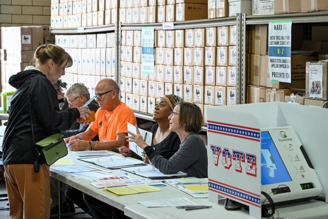 Funcionários da mesa eleitoral registram um eleitor em uma seção eleitoral na Estação de Relações Comunitárias n&ordm; 6 do Corpo de Bombeiros de Milwaukee, em Milwaukee, Wisconsin.