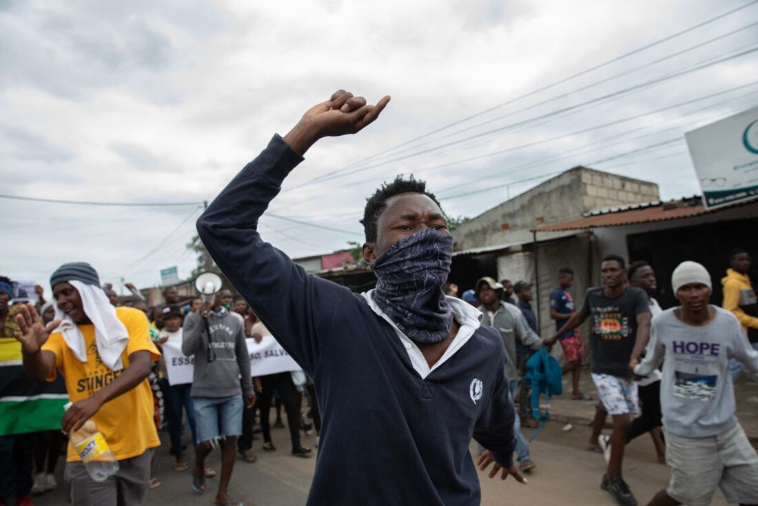 Um manifestante mascarado gesticula durante um protesto contra o governo no bairro de Patrice Lumumba, em Maputo