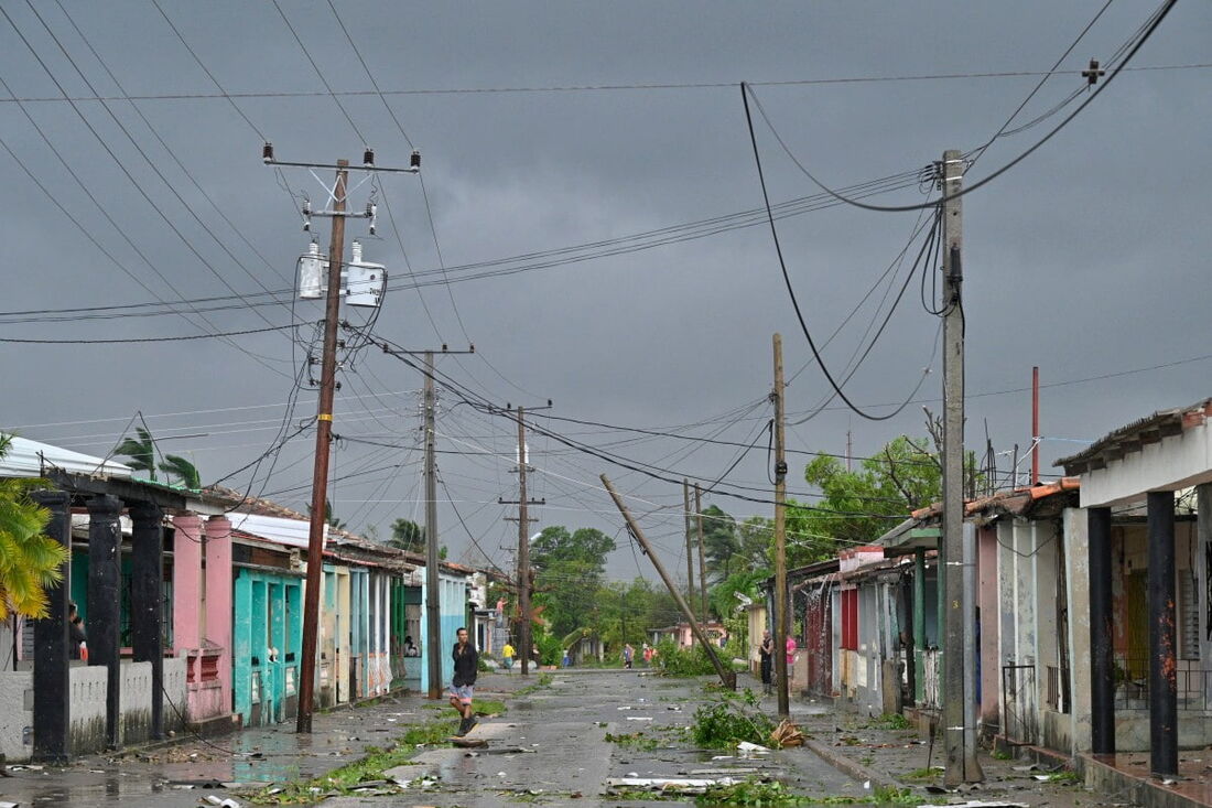 Um homem caminha em uma rua durante a passagem do olho do furacão Rafael em Pueblo Candelaria, província de Artemisa, 65 km a oeste de Havana, em 6 de novembro de 2024. 