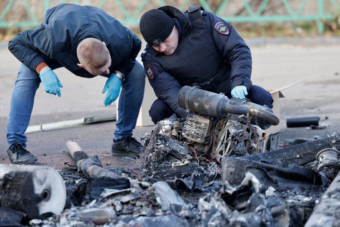 Policiais russos inspecionam os destroços de um drone após