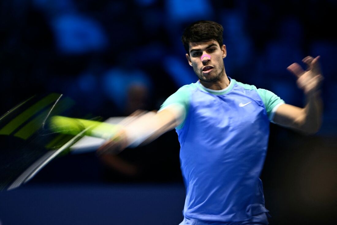 O espanhol Carlos Alcaraz rebate o russo Andrey Rublev durante a partida no torneio de tênis ATP Finals em Turim