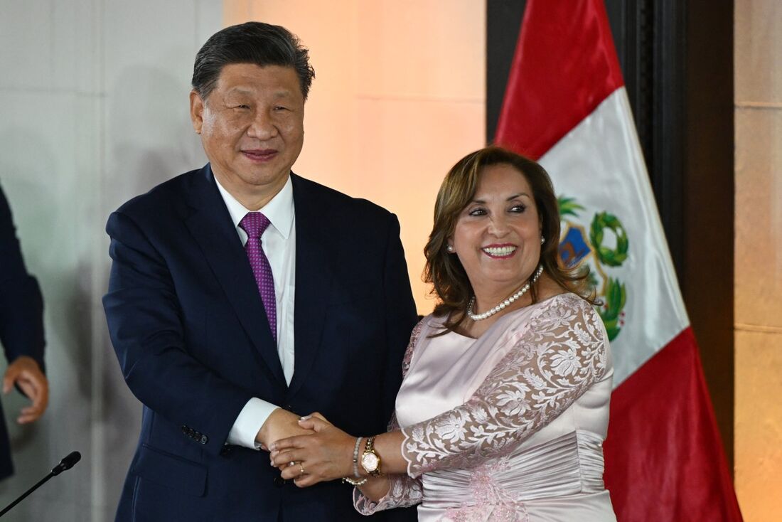 O presidente da China, Xi Jinping (E), e a presidente do Peru, Dina Boluarte, apertam as mãos durante uma reunião no palácio do governo em Lima, em 14 de novembro de 2024, à margem da Cúpula de Cooperação Econômica Ásia-Pacífico (APEC).