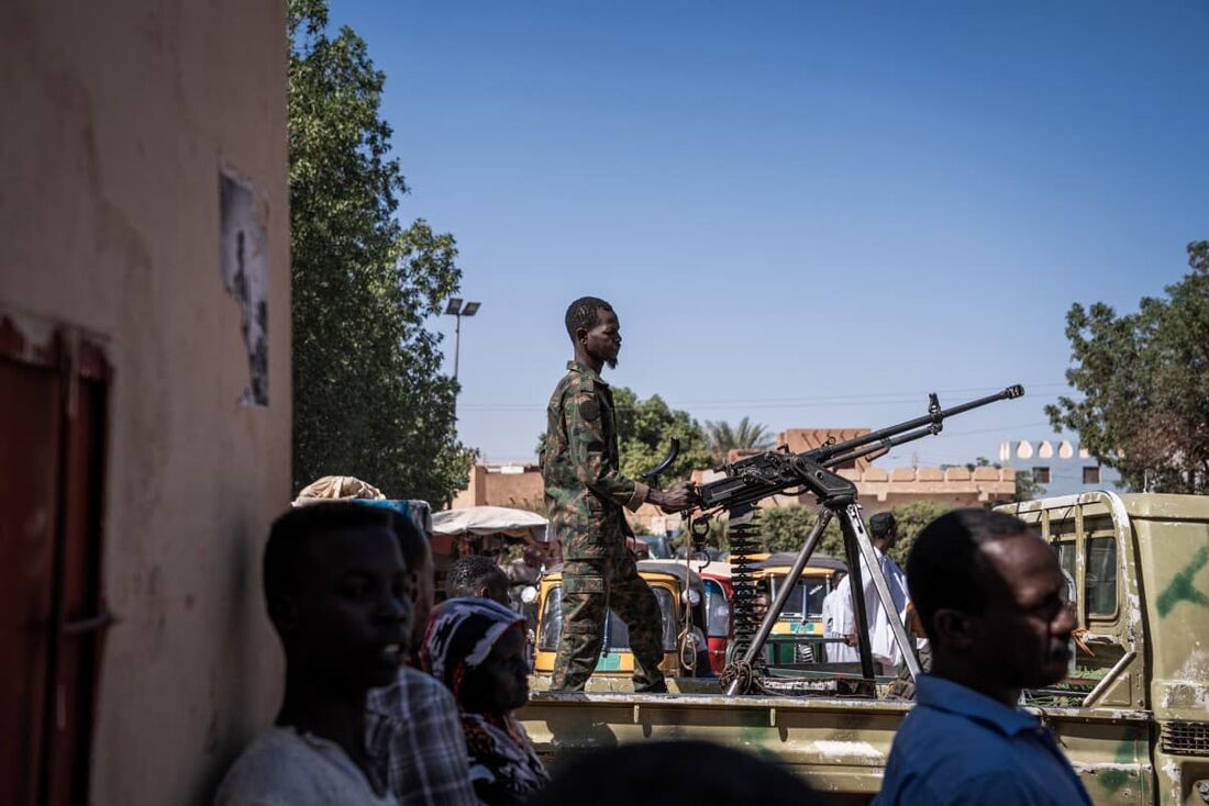 Um soldado do exército sudanês opera uma metralhadora em cima de uma caminhonete militar do lado de fora de um hospital em Omdurman em 2 de novembro de 2024.