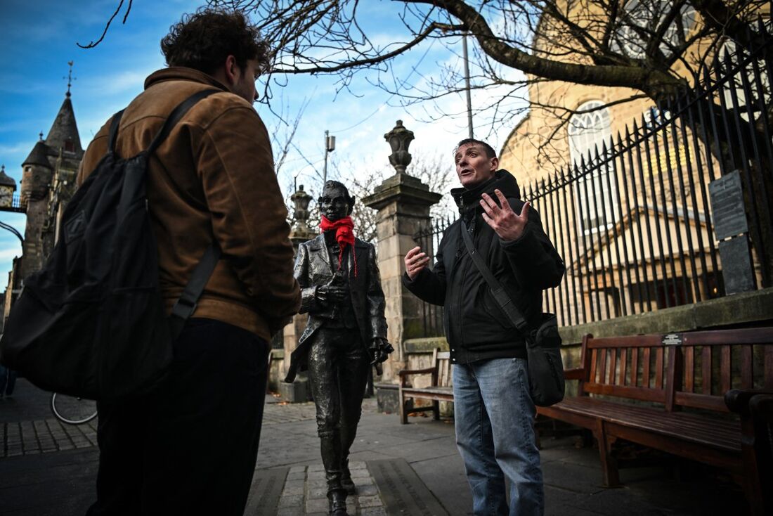 Guia das Cidades Invisíveis Sonny Murray lidera um passeio a pé com o aluno Arthur Lyhne-Gold, em frente à Cannongate Kirk, Edimburgo