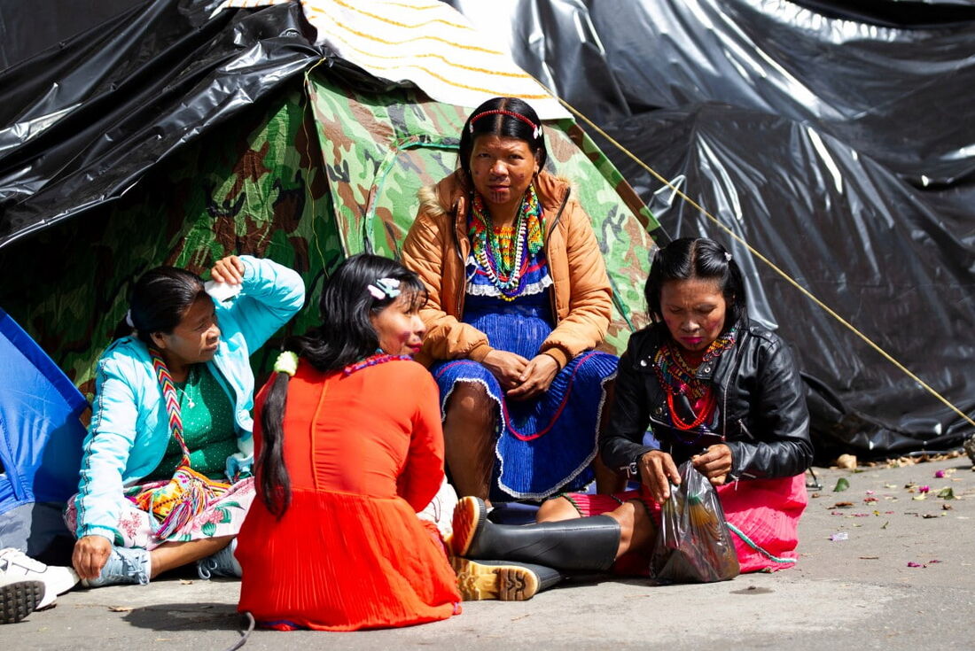 Mulheres indígenas Embera esperam em uma tenda improvisada durante um protesto em Bogotá em 26 de novembro de 2024. 