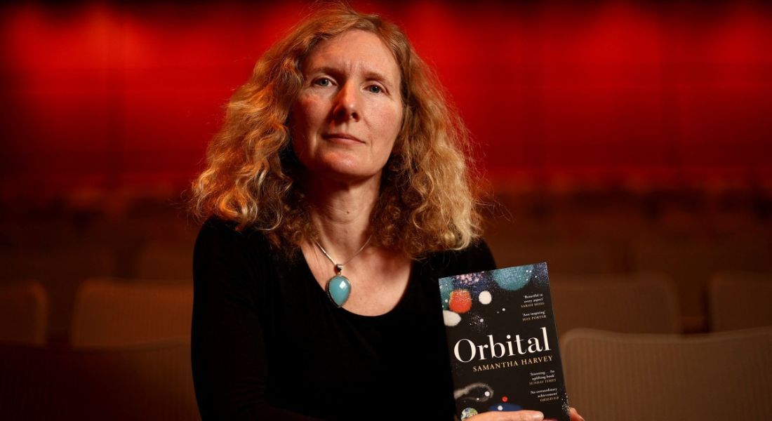 Escritora Samantha Harvey com o livro Orbital