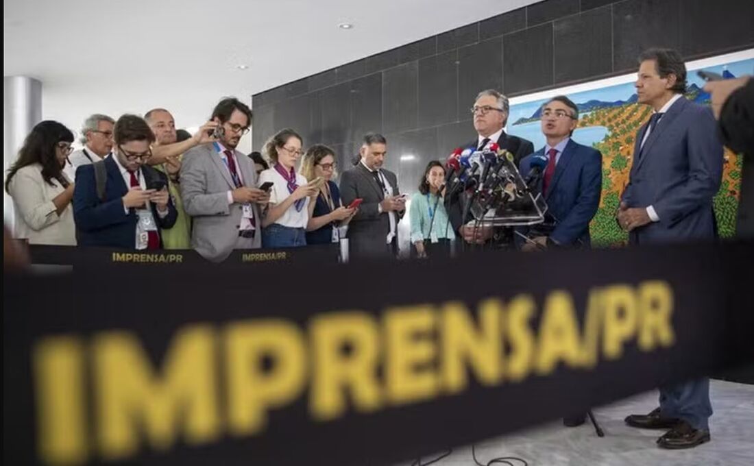 O presidente da Febraban, Isaac Sidney, fala com a imprensa ao lado dos ministros Alexandre Padilha e Fernando Haddad após encontro com Lula 