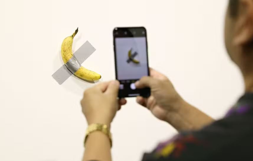 Olhando para "Comedian", de Maurizio Cattelan, uma banana colada na parede com fita adesiva, na prévia da Sotheby's. Quem está rindo? Estima-se que seja vendida por valores entre US$ 1 milhão e US$ 1,5 milhão 