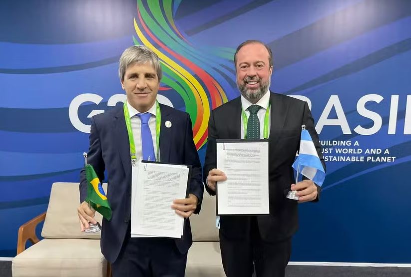 Ministro da Economia da Argentina, Luis Caputo (à esquerda), e ministro de Minas e Energia do Brasil, Alexandre Silveira (à direita) assinam acordo de fornecimento de gás argentino para o Brasil