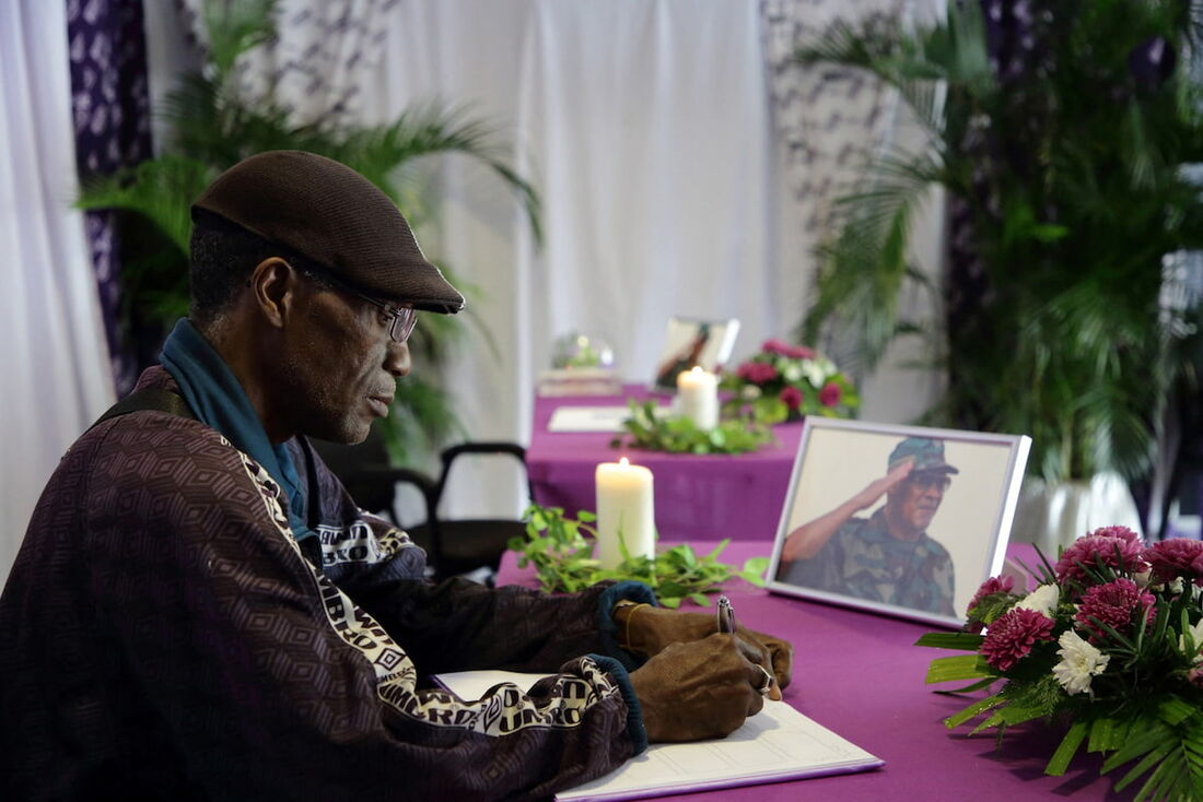 Um membro do Partido Democrático Nacional (NDP) e apoiador do falecido ex-presidente surinamês Desi Bouterse assina o registro de condolências no centro OCER em Paramaribo em 30 de dezembro de 2024. 