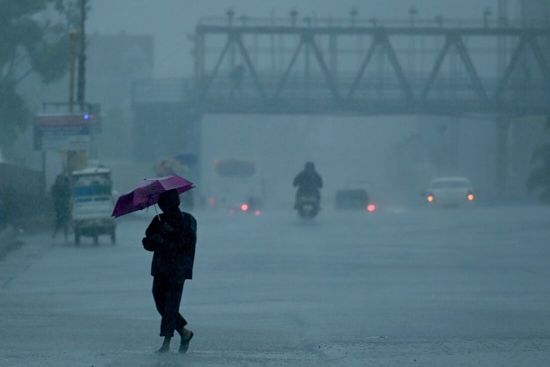 Pessoas em meio a fortes chuvas antes de uma tempestade ciclônica