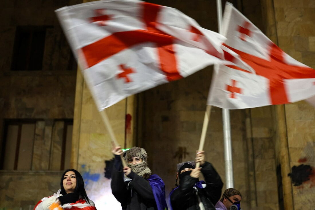  Manifestantes agitam bandeiras georgianas durante a quinta noite consecutiva de manifestações contra o adiamento do governo das negociações de adesão à UE até 2028