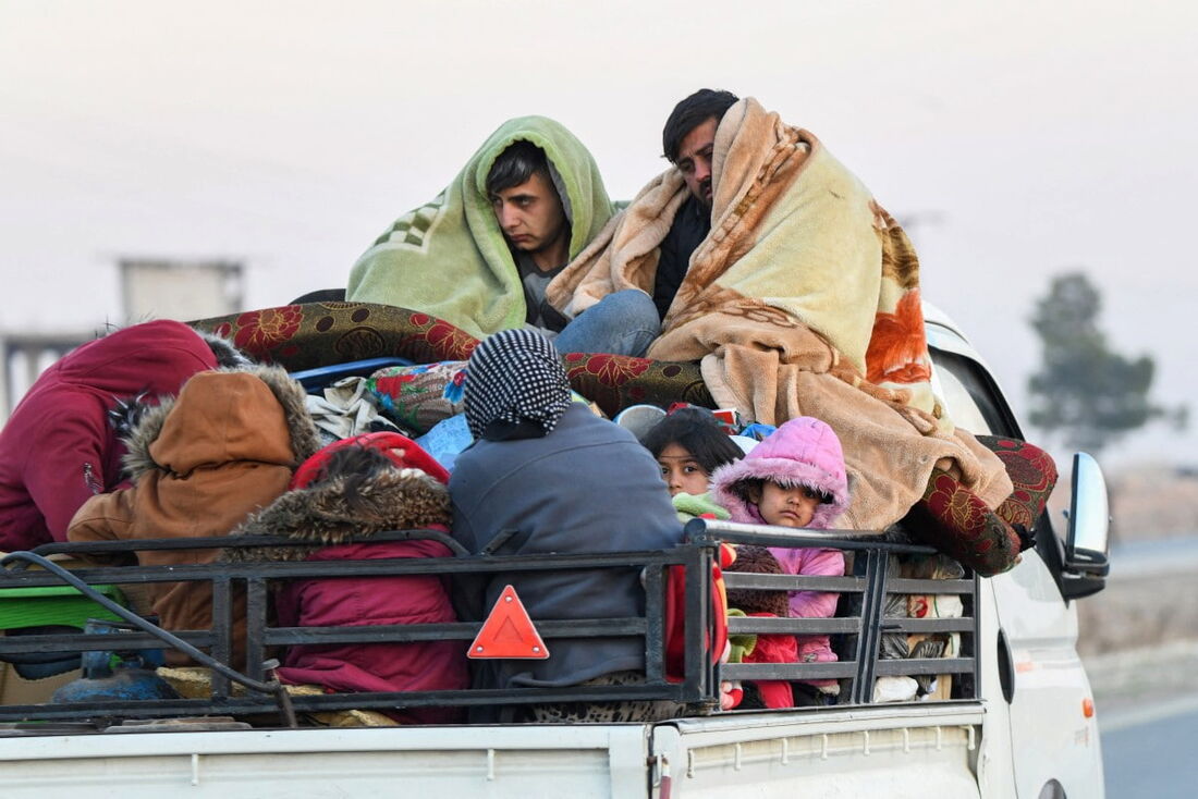 Curdos sírios deslocados viajam em veículos carregados com pertences na rodovia Aleppo-Raqqa enquanto fogem de áreas nos arredores da cidade de Aleppo