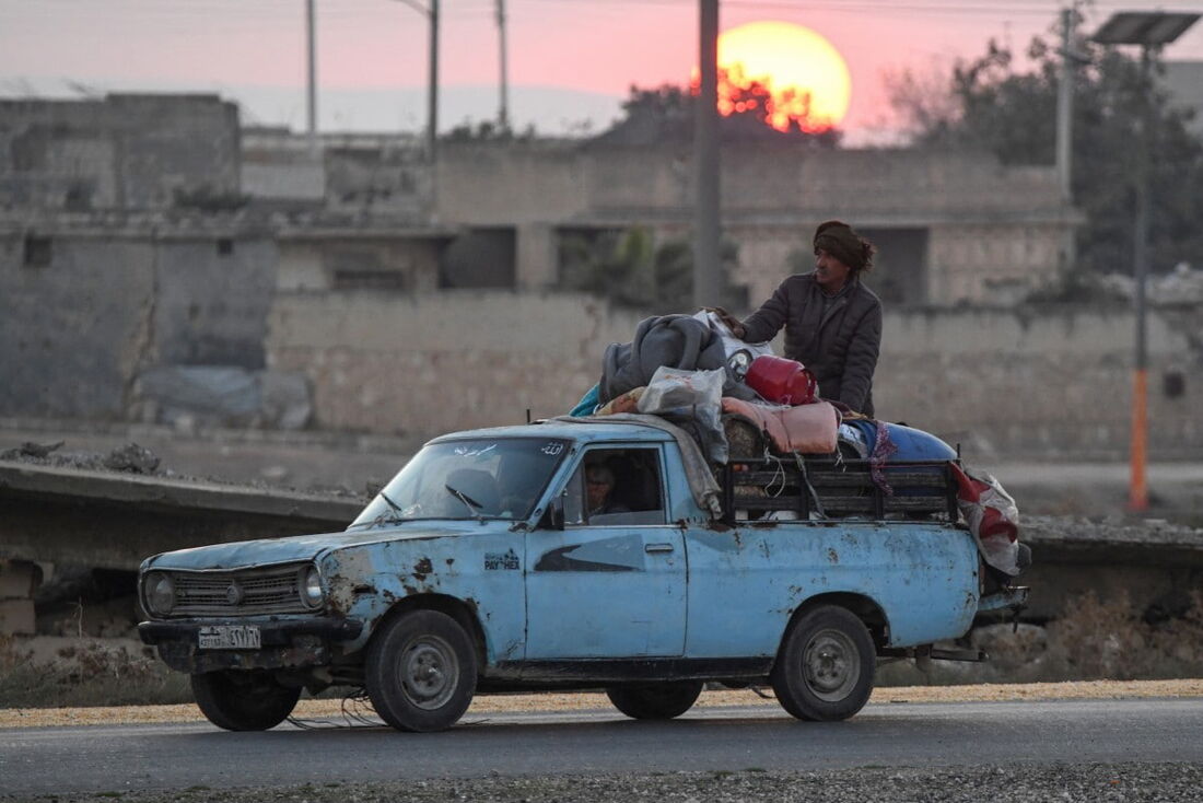 Curdos sírios deslocados dirigem um veículo carregado com pertences na rodovia Aleppo-Raqqa para fugir de áreas nos arredores da cidade de Aleppo