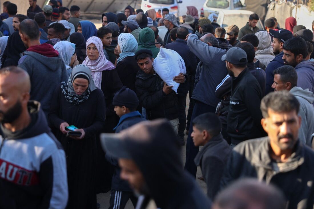 Palestinos fazem fila para obter suas provisões de farinha da Agência da ONU para os Refugiados Palestinos