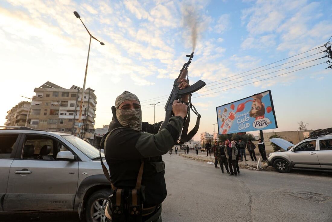 Um combatente sírio antigoverno dispara seu rifle para o ar nas ruas da cidade de Hama, no centro-oeste, em 5 de dezembro de 2024.