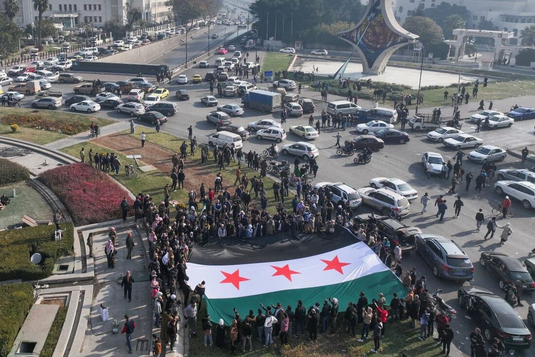 Sírios se aglomeraram na praça principal da capital Damasco em 9 de dezembro para marcar o que muitos consideram um novo amanhecer há muito aguardado após a queda do presidente Bashar al-Assad. 