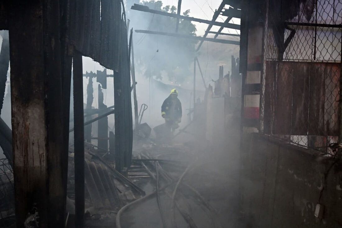 Um bombeiro trabalha para apagar um incêndio no mercado Las Americas em Tegucigalpa em 13 de dezembro de 2024. 