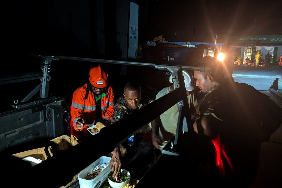 Equipes de resgate fazem uma pausa para comer no local de um prédio desabado após um terremoto atingir Port Vila, capital de Vanuatu