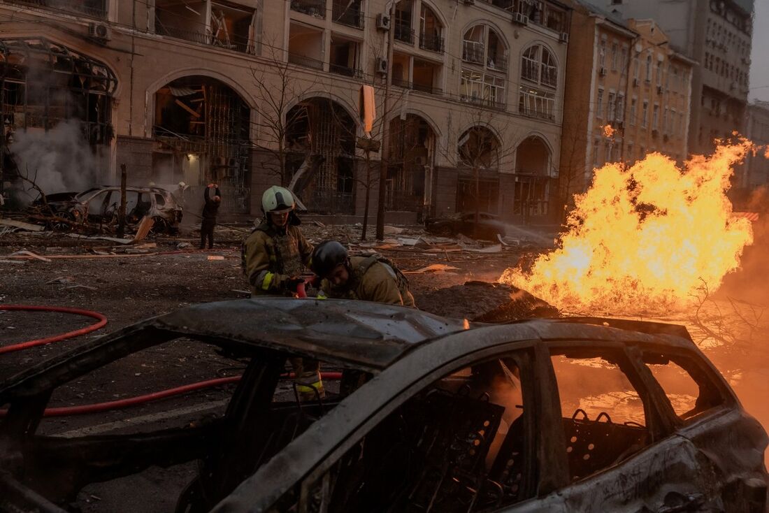 Bombeiros ucranianos tentam extinguir um incêndio no local de um ataque com mísseis russos em Kiev, em 20 de dezembro de 2024, em meio à invasão russa na Ucrânia