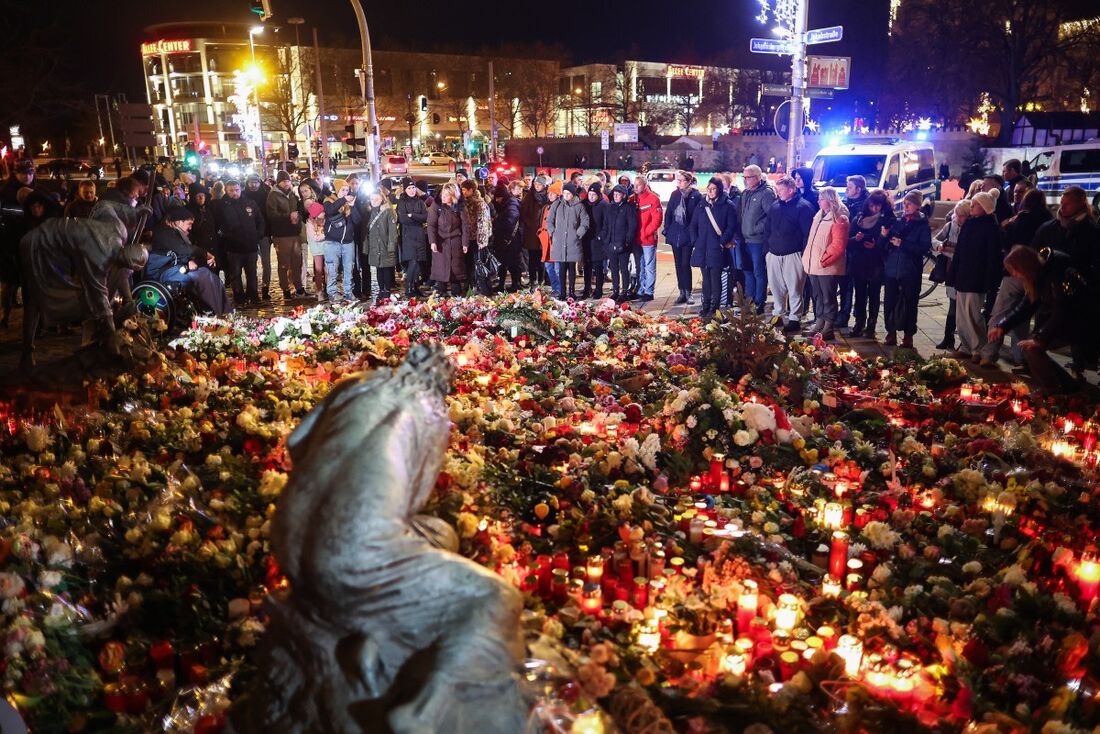 Pessoas colocam flores em um memorial improvisado perto do local de um ataque com um carro em um mercado de Natal em Magdeburg, no leste da Alemanha